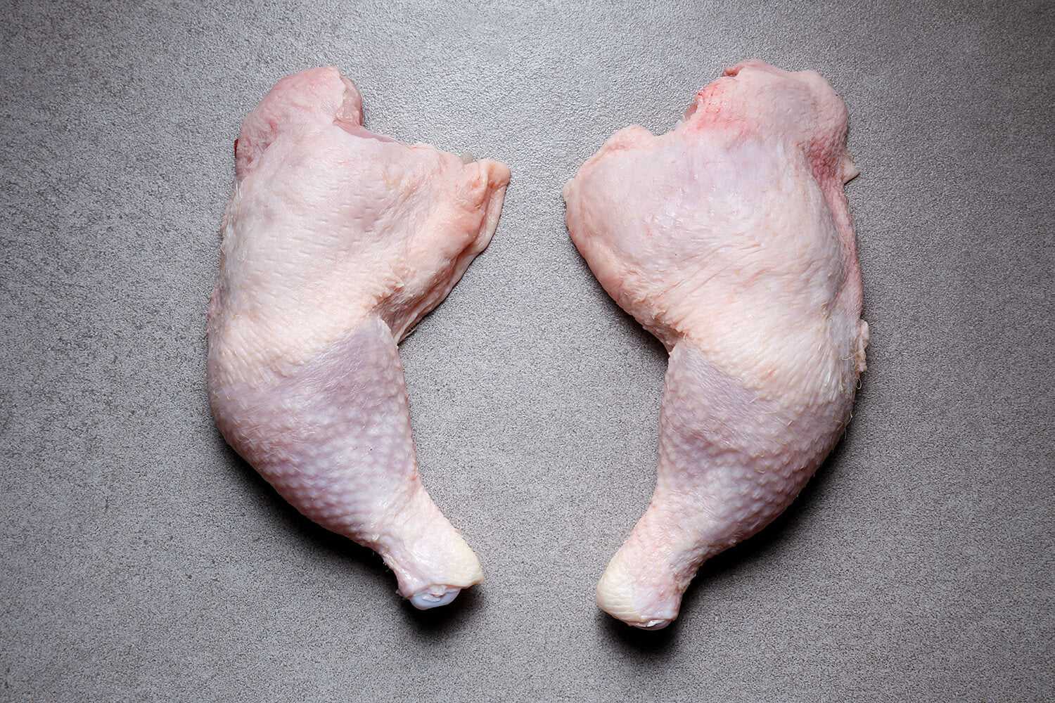 Raw skin-on chicken legs (1 kg), pale pink drumsticks