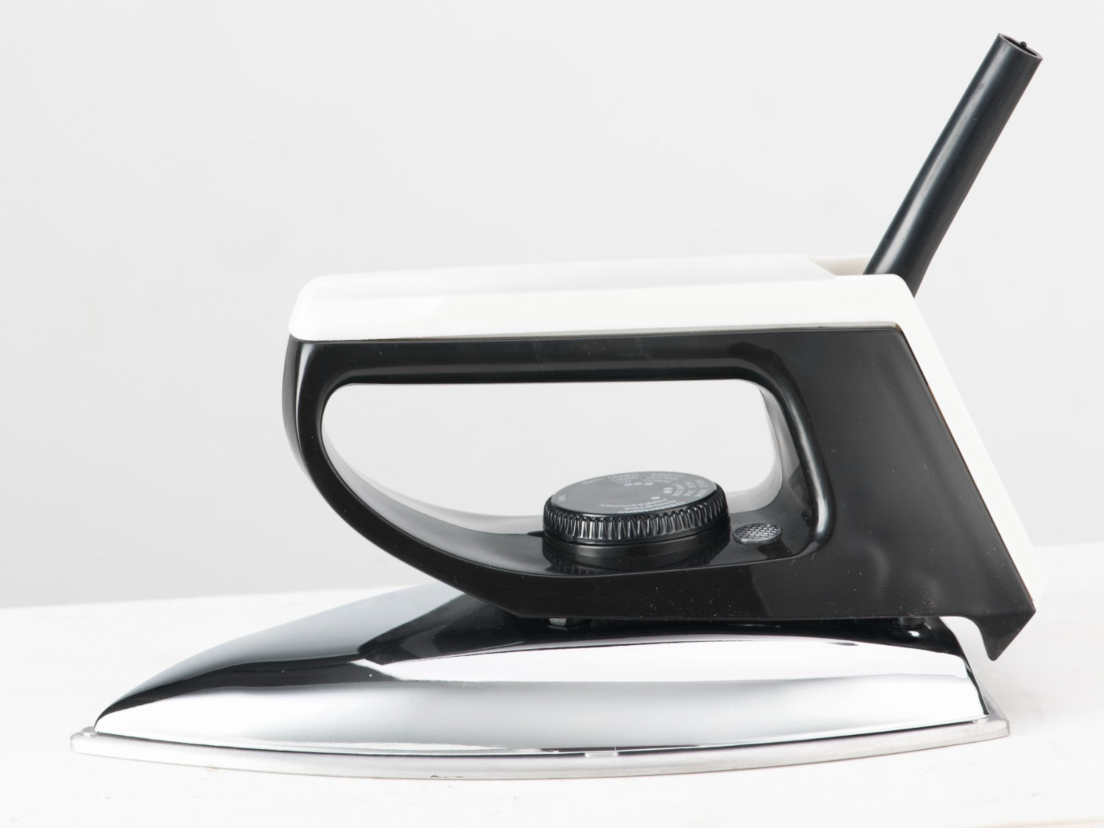 Black and silver dry iron with textured handle and soleplate
